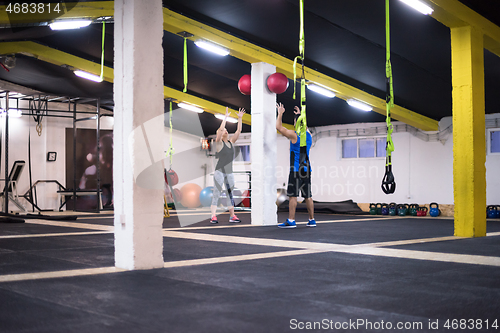 Image of young athletes couple working out with medical ball