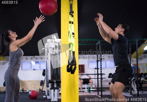 Image of young athletes couple working out with medical ball