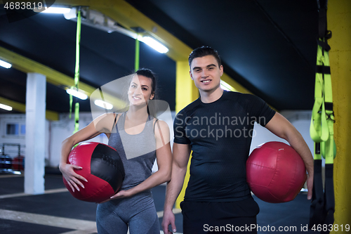 Image of young athletes couple working out with medical ball