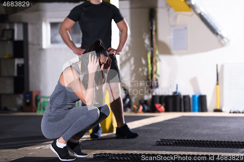 Image of sports couple doing battle ropes cross fitness exercise