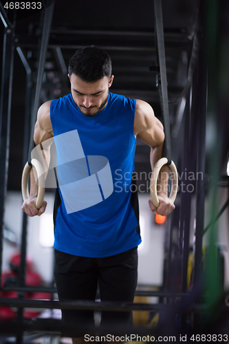 Image of man working out pull ups with gymnastic rings