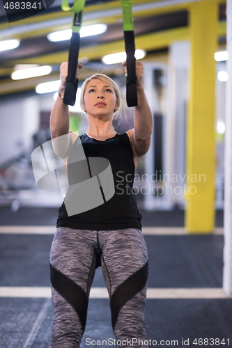 Image of woman working out pull ups with gymnastic rings