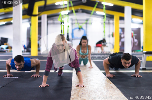 Image of young healthy people doing pushups