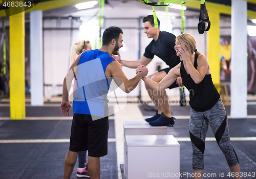 Image of athletes working out  jumping on fit box