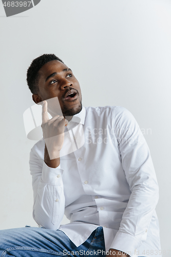 Image of Remember all. Let me think. Doubt concept. Doubtful, thoughtful afro man remembering something. Young emotional man. Human emotions, facial expression concept. Studio. Isolated on trendy green. Front