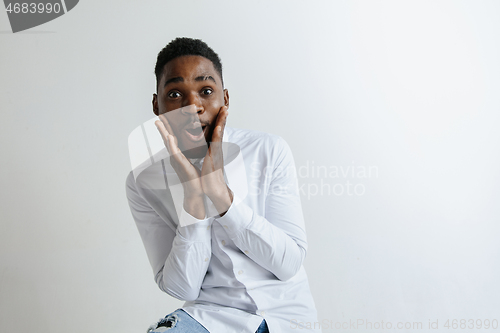 Image of Portrait of excited young African American male screaming in shock and amazement.