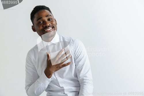 Image of Grateful happy pleased african man holding hands on chest.