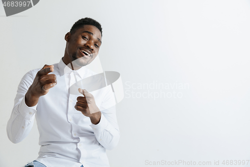 Image of Afro american man over isolated grey background pointing with finger to the camera and to you, hand sign, positive and confident gesture from the front