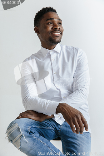 Image of Close up portrait of a happy young african american man laughing against gray background.