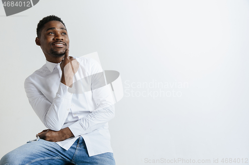 Image of Close up portrait of a happy young african american man laughing against gray background.