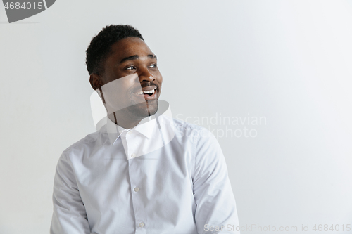 Image of Close up portrait of a happy young african american man laughing against gray background.