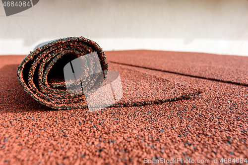 Image of Bitumen roll shingles are laid on the roof on which a roll of shingles lies