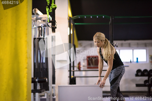 Image of woman working out  jumping on fit box