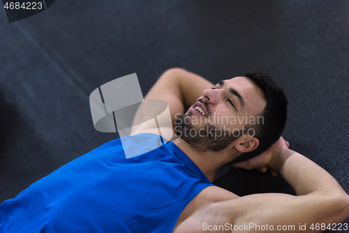 Image of young athlete man lying on the floor and relaxing