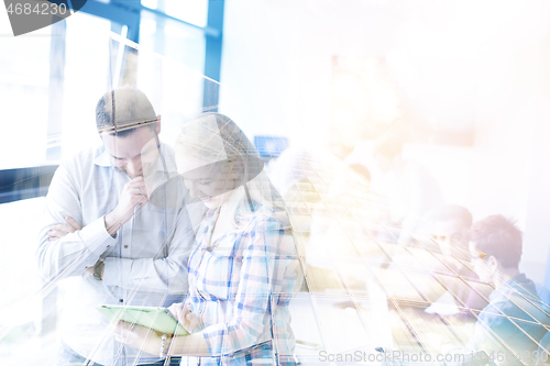 Image of Two Business People Working With Tablet in office