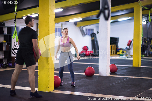 Image of young athletes couple working out with medical ball