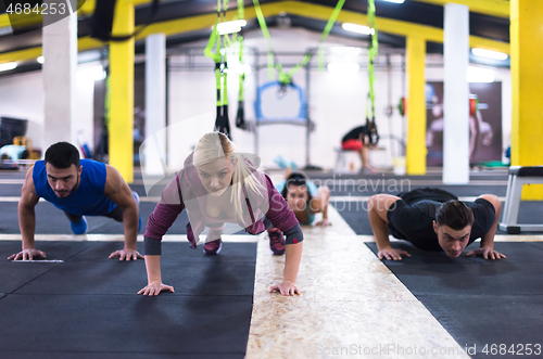 Image of young healthy people doing pushups