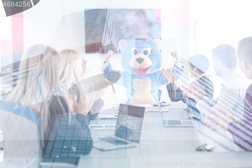 Image of boss dresed as bear having fun with business people in trendy of