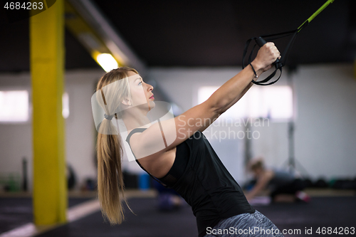 Image of woman working out pull ups with gymnastic rings