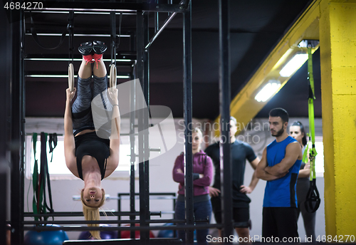 Image of woman working out with personal trainer on gymnastic rings