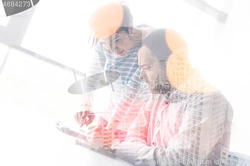 Image of Two Business People Working With Tablet in startup office