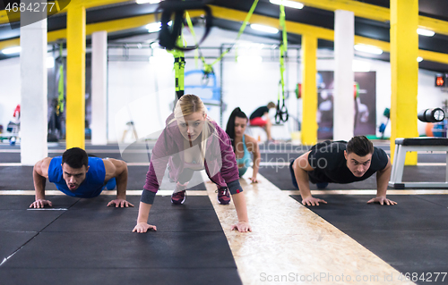 Image of young healthy people doing pushups