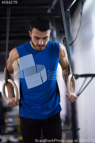 Image of man working out pull ups with gymnastic rings