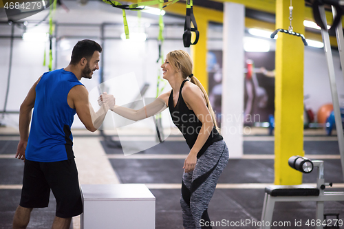 Image of woman working out with personal trainer jumping on fit box