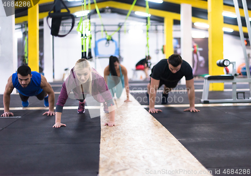 Image of young healthy people doing pushups