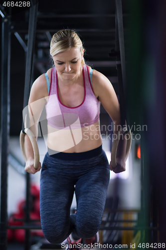 Image of woman working out pull ups with gymnastic rings