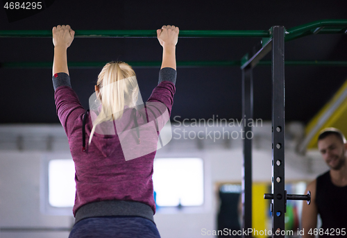 Image of woman doing pull ups on the horizontal bar