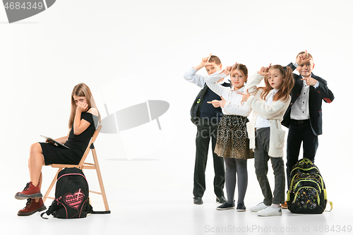 Image of Little girl sitting alone on chair and suffering an act of bullying.