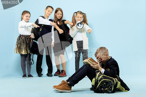 Image of Little boy sitting alone on floor and suffering an act of bullying.