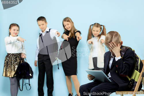 Image of Little boy sitting alone on chair and suffering an act of bullying.