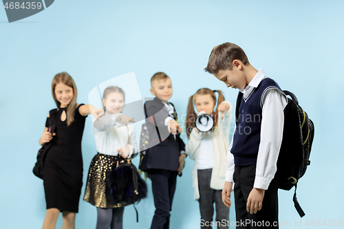 Image of Little boy standing alone and suffering an act of bullying.