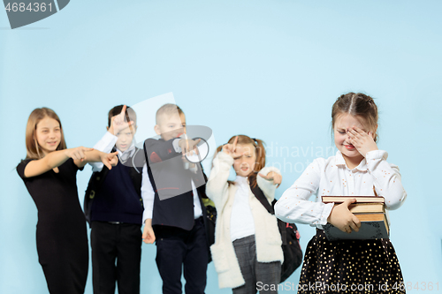 Image of Little girl sitting alone on chair and suffering an act of bullying.