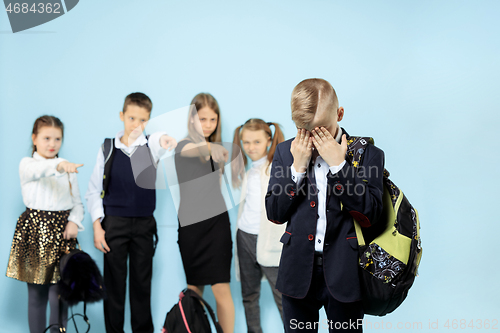 Image of Little boy standing alone and suffering an act of bullying.