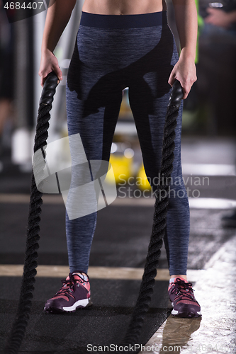 Image of athlete woman doing battle ropes cross fitness exercise