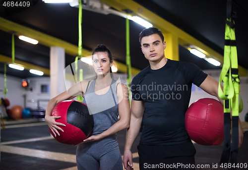 Image of young athletes couple working out with medical ball