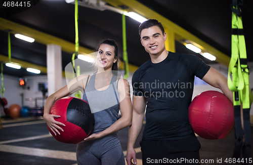 Image of young athletes couple working out with medical ball