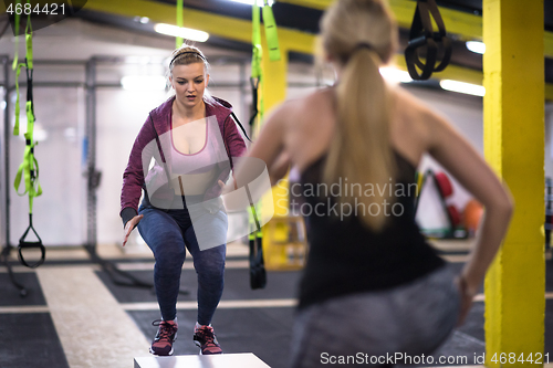 Image of athletes working out  jumping on fit box