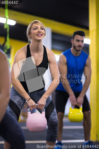 Image of athletes doing exercises with kettlebells