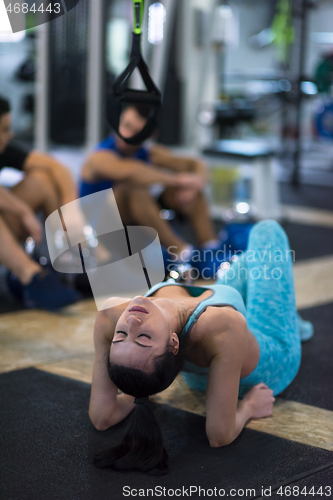 Image of young athlete woman lying on the floor and relaxing