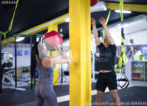 Image of young athletes couple working out with medical ball