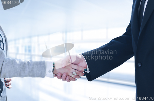 Image of Businessman and businesswoman shaking hands after meetup