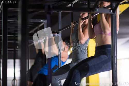 Image of young athletes doing pull ups on the horizontal bar