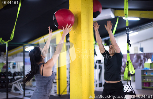 Image of young athletes couple working out with medical ball