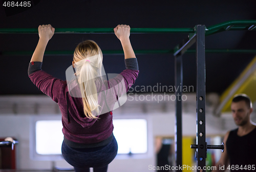 Image of woman doing pull ups on the horizontal bar