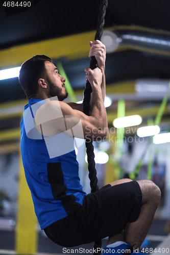 Image of man doing rope climbing