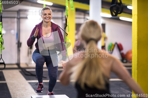 Image of athletes working out  jumping on fit box